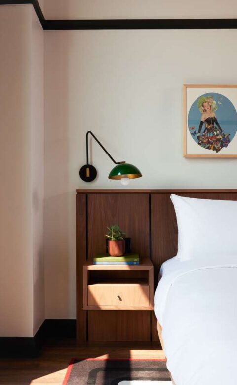 a bedroom with a bed, nightstand, and pictures on the wall