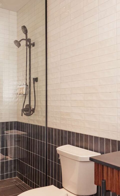 a white toilet next to a shower in a bathroom