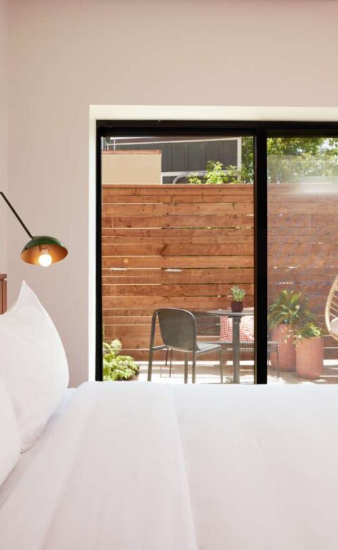 a bed with white sheets and pillows in a bedroom