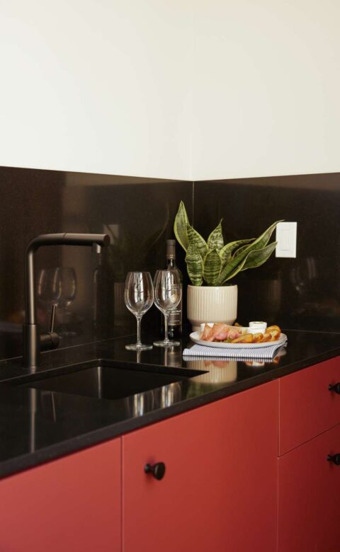 a kitchen counter with a glass of wine and a plate of food