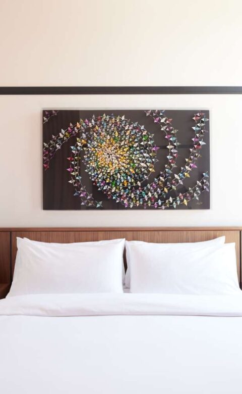 a bed with white sheets and pillows in a bedroom