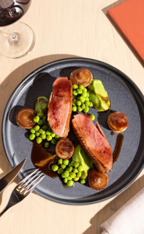 a plate of food with peas, mushrooms and bacon