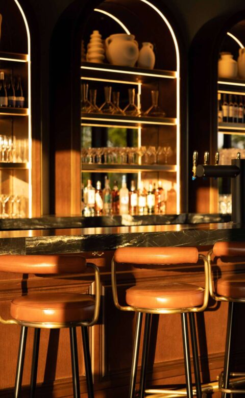 a row of bar stools sitting in front of a bar