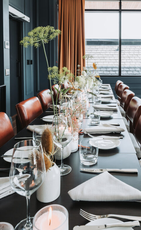 Long Dining table with Chairs and plates kept on table
