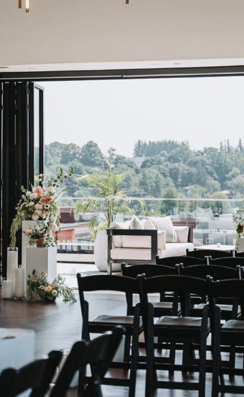 a room filled with lots of black chairs next to a window