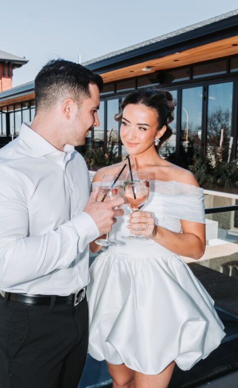 a man standing next to a woman holding a glass of wine