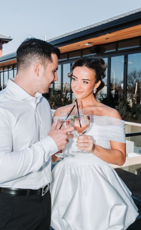 a man standing next to a woman holding a glass of wine
