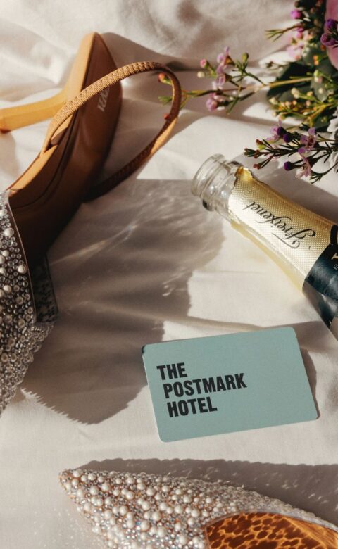 a pair of shoes and a bottle of champagne on a bed