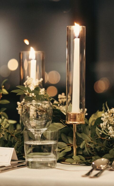 a close-up of a table with a candle and flowers