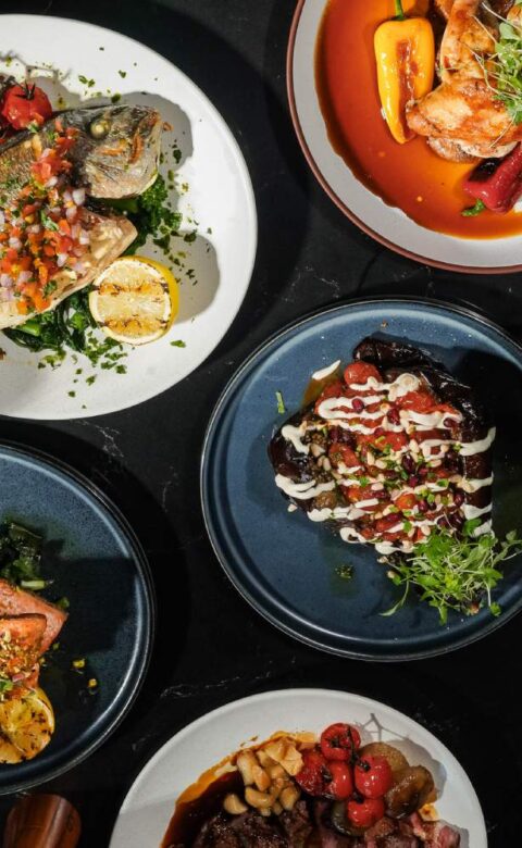 a table topped with plates of food and glasses of wine