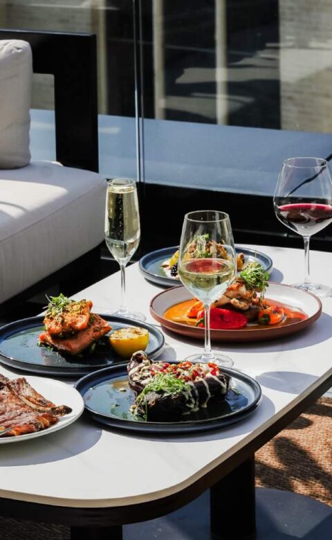 a table topped with plates of food and glasses of wine