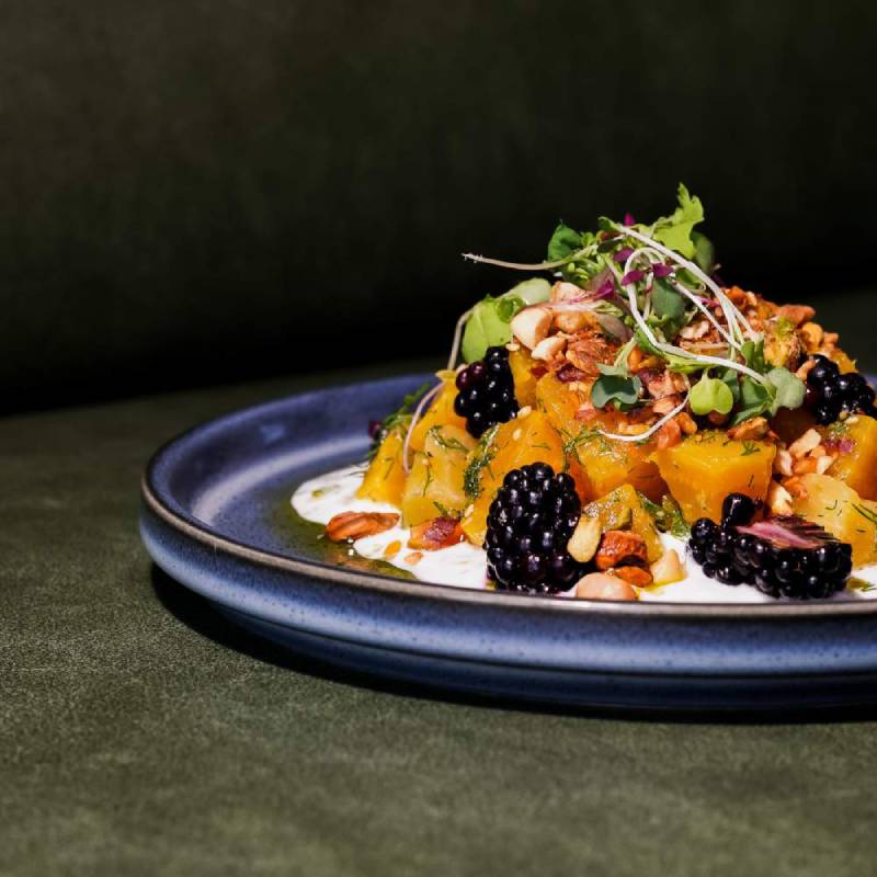 a fruit salad with yoghurt on a blue plate